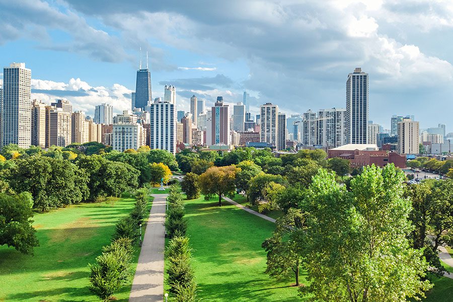 Contact - Aerial Drone View of Chicago Skyline From Above Displaying Many Tall Buildings and Trees From Lincoln Park